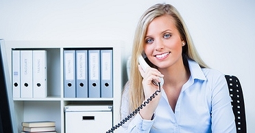 Bürokauffrau telefoniert am Arbeitsplatz